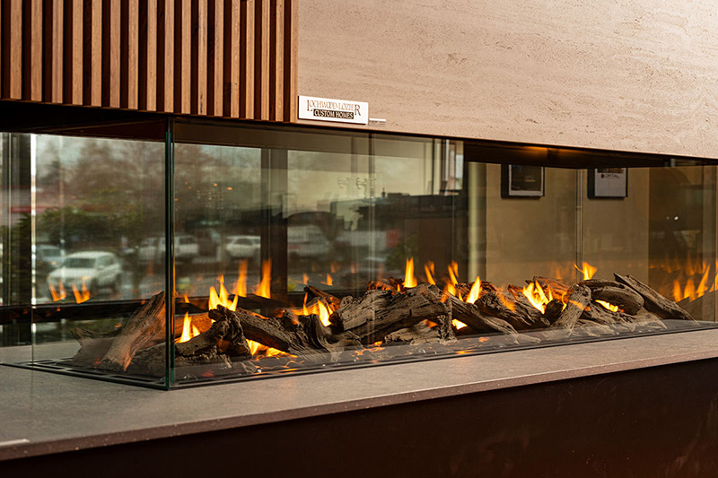 A fireplace with glass barriers fit into a wall