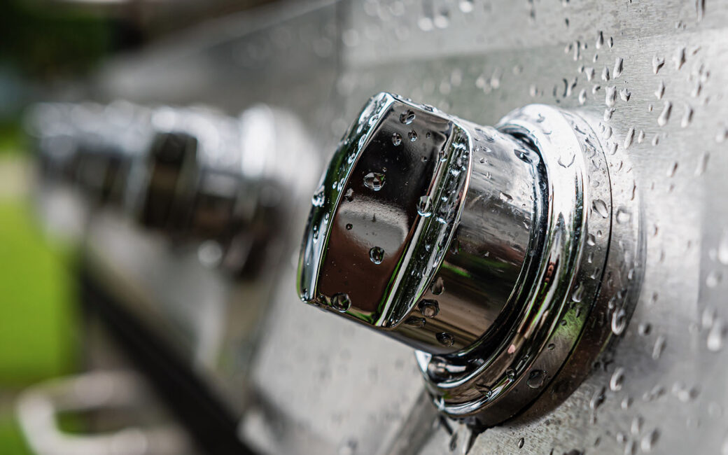 drops of water in a switch panel on the electric stainless steel grill, close-up